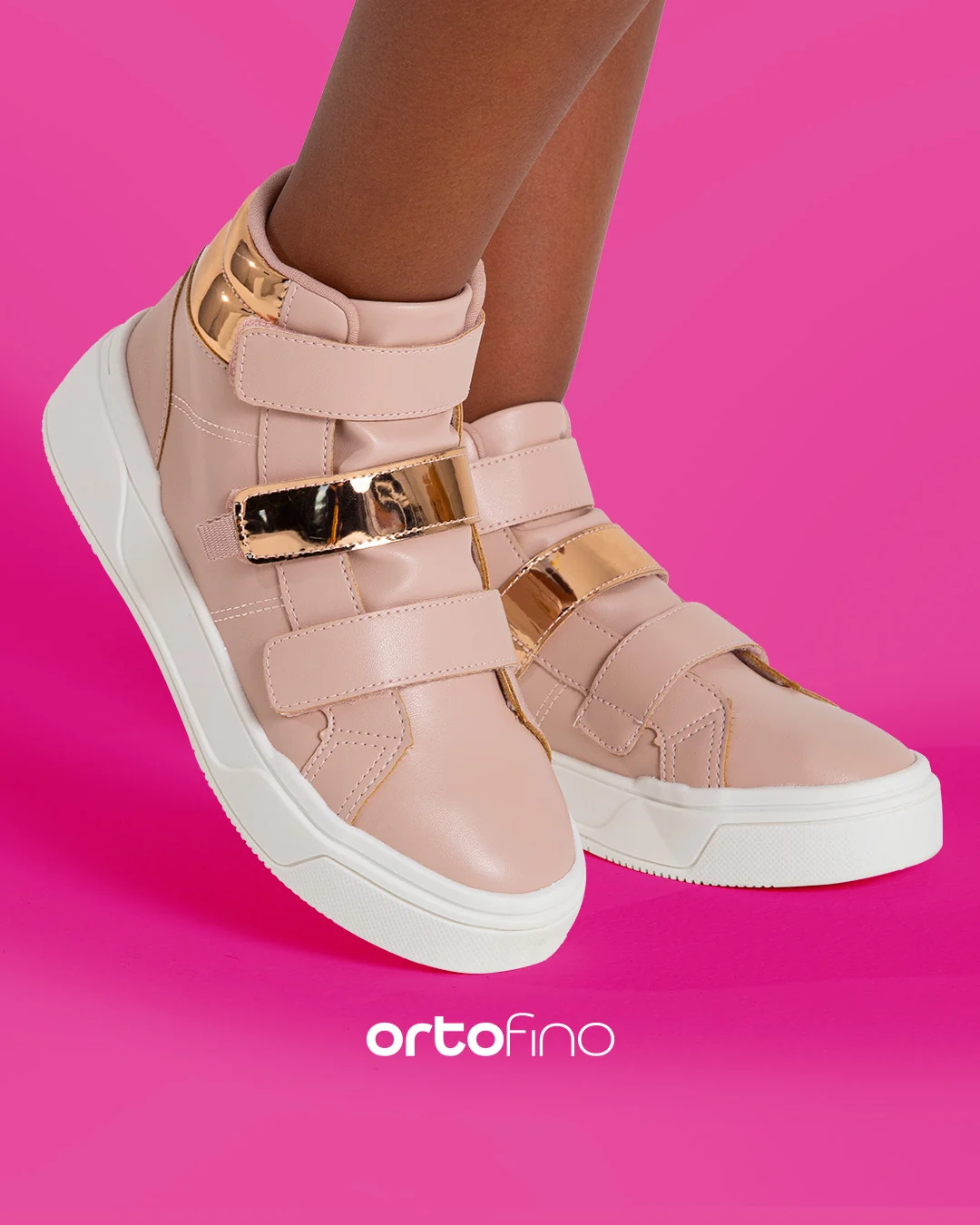 Post da Ortofino: pés calçando tênis cano alto rosa-claro com fivelas douradas, sobre fundo rosa.
